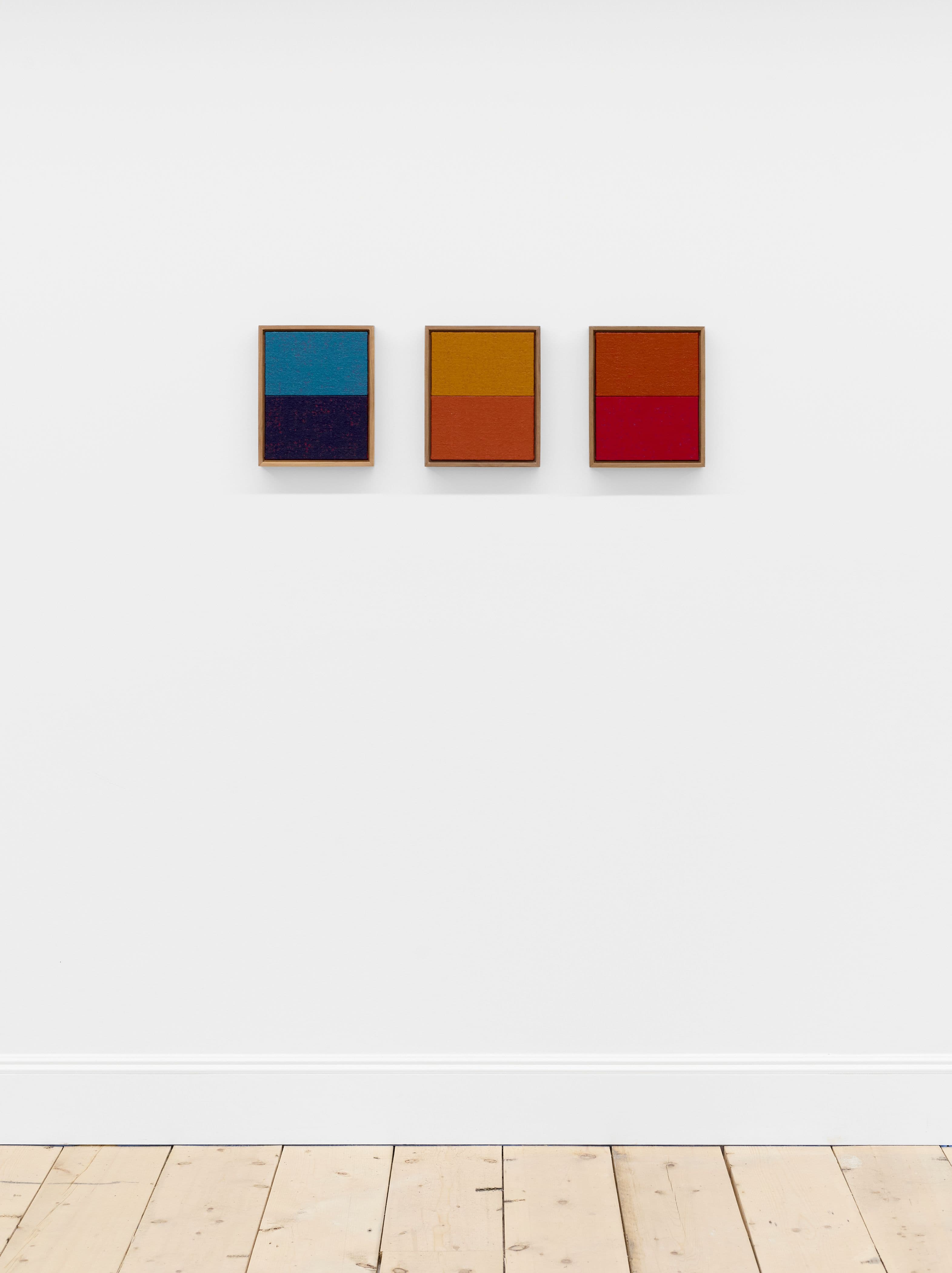 Three abstract paintings, framed on a white wall.